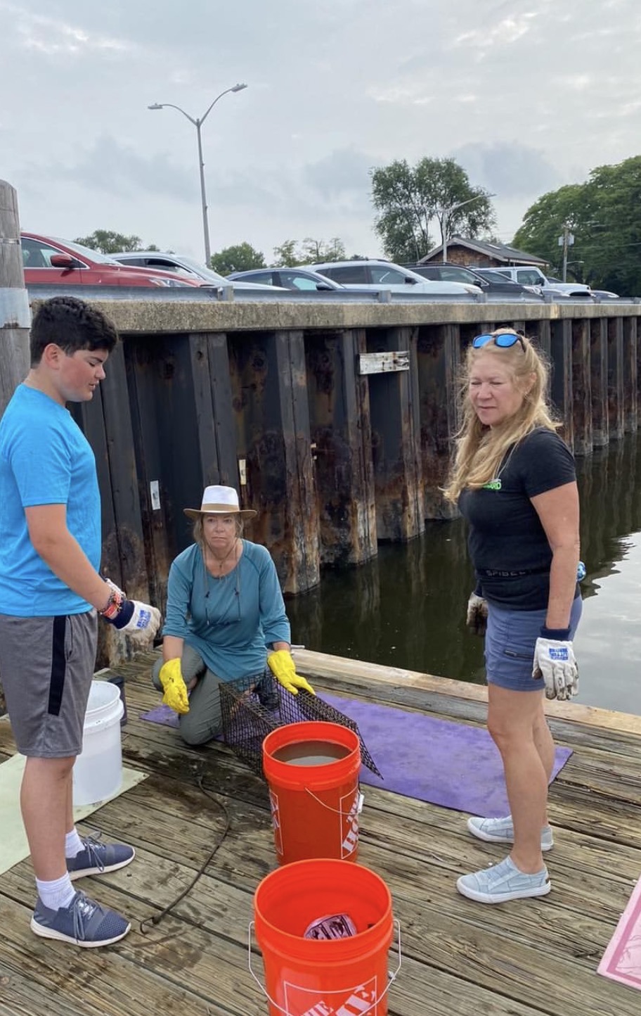 Gabriel Jaffe helping build a marine oyster garden on a dock with Residents Forward volunteers